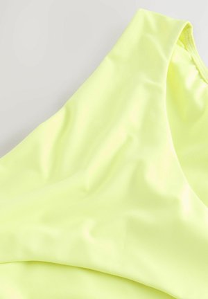 Neon geltonas bikini viršus, pagamintas iš lygaus, tampraus audinio su švariu dizainu. Jame yra platus peties diržas ir jokios matomos metalinės detalės.