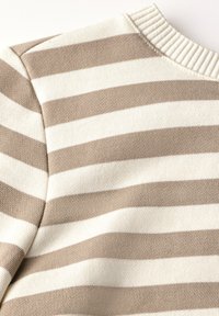 Tejido de punto a rayas en color beige y blanco roto con un cuello redondo acanalado. La textura es suave, con patrones y costuras horizontales regulares.