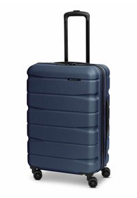 Valise rigide bleu foncé à surface texturée, quatre roues pivotantes et poignée télescopique noire déployée.