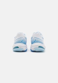 Baskets de sport blanches avec des accents dégradés bleus, tige en mesh, semelle amortissante, et un logo distinct sur le talon et sur les côtés. Ajustement s'adaptant.