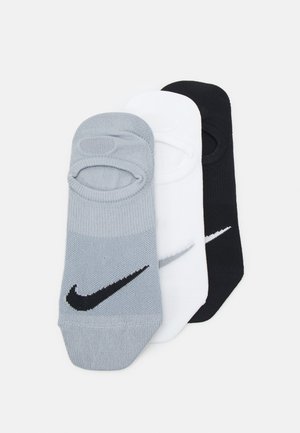 Kolme paria matalalaisia sukkia harmaasta, valkoisesta ja mustasta materiaalista. Jokaisessa on Nike-logo ylhäällä tasaisella pinnalla.