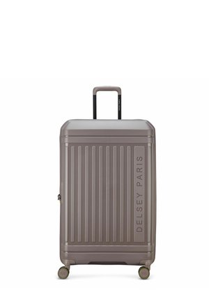 Hard-shell gray suitcase with vertical ridges, telescopic handle, four swivel wheels, and "Delsey Paris" branding on the front.