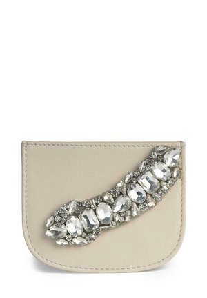 Portafoglio in pelle beige con un'aggiunta curva di grandi e piccoli strass, che conferisce texture e interesse visivo al design.
