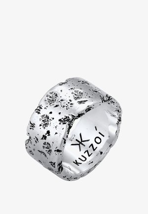 Sidabrinės spalvos žiedas su faktūringu, nelygiu paviršiumi, ant kurio matyti gėlių įspaudi. Viduje matomas įrašytas prekės ženklas „Kuzzoi“.