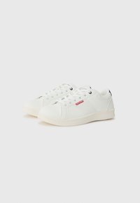 White sneakers with a smooth texture, featuring mesh detailing on the sides, round toe, white laces, and a rubber sole.