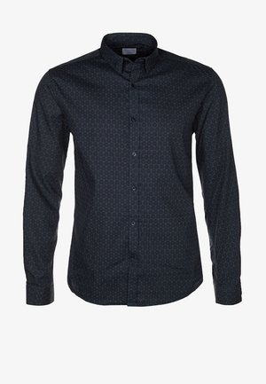 Schwarze Motorradjacke aus Leder, blau gemustertes Hemd, schwarze Jeans und schwarze Schnürstiefel mit braunen Sohlen. Lässiges, geschichtetes Outfit.