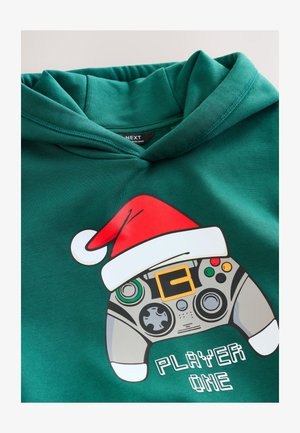 Sudadera con capucha verde con un gráfico de un mando de juego adornado con un gorro de Santa rojo, texto "PLAYER ONE" en fuente pixelada blanca. Textura suave.