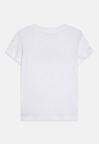 Camiseta de algodón blanca con mangas cortas, cuello redondo y dobladillo cosido. Presenta una textura suave y sin patrones ni gráficos visibles.