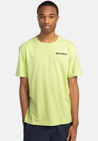 Kortærmet t-shirt med rund hals i lys limegrøn bomuld. Har et lille sort "ELEMENT"-logo på brystet. Glat tekstur.