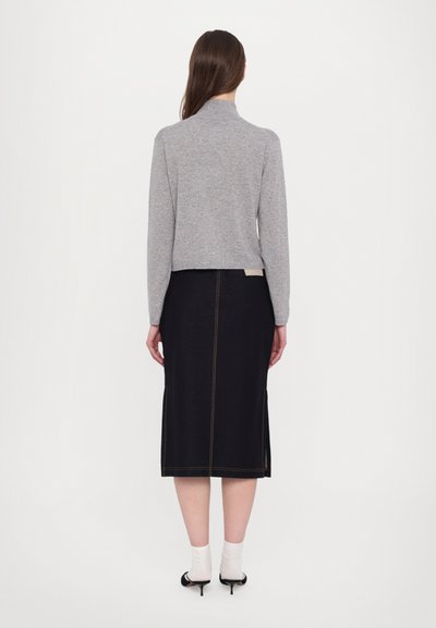 Γκρι, πουκάμισο με μακρύ μανίκι και ψεύτικο λαιμό, συνδυασμένο με μία μαύρη, μεσαίου μήκους φούστα με πίσω ραφή και πλαϊνές σχισμές. Μαύρα τακούνια και λευκές κάλτσες.