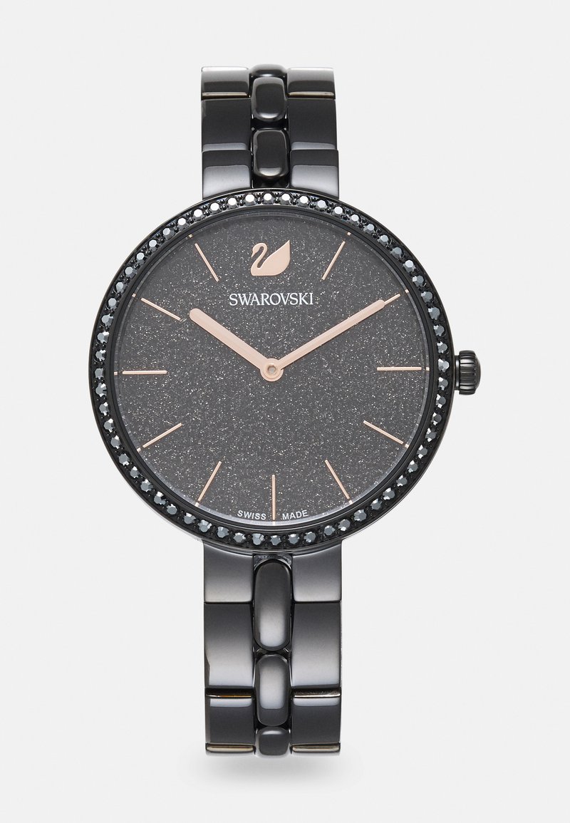 Orologio metallizzato nero con quadrante a texture scura, dettagli in oro rosa e un cinturino decorato con cristalli neri. Presenta un design a bracciale collegato.