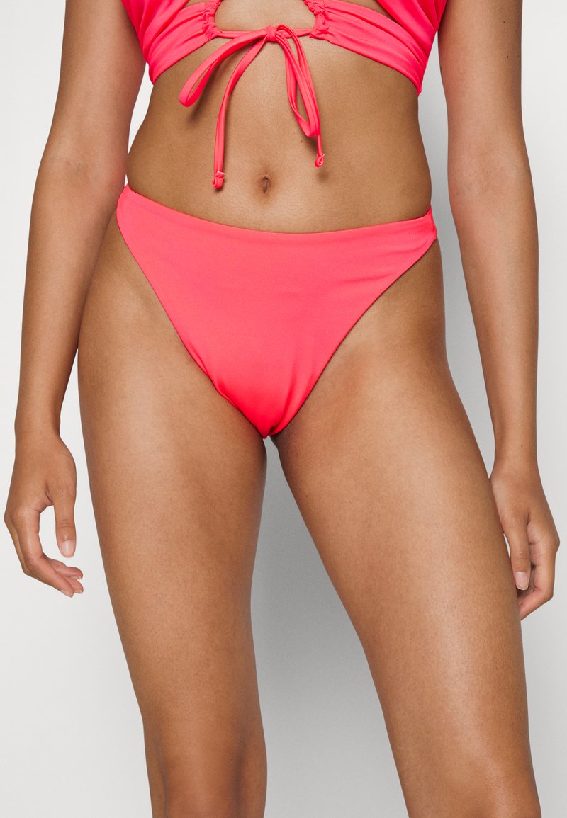 Conjunto de biquíni neon rosa com um topo amarrado à frente e um recorte, e parte de baixo de cintura alta. Material suave e elástico com costuras mínimas.