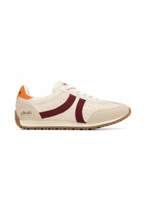 Zapatilla beige de ante con rayas burdeos, detalles perforados, cordones blancos, lengüeta naranja en el talón y suela de goma marrón.