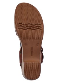 Brown rubber sandal sole with textured wavy patterns. Features embossed brand name and size details. Flat design with low-profile heel.