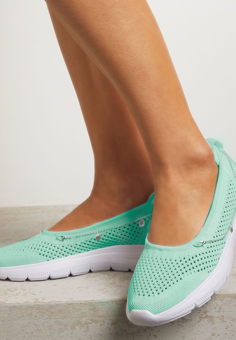 Leichte mintgrüne Slip-On-Schuhe aus atmungsaktivem Mesh mit einer strukturierten Oberseite. Merkmale eine weiße Gummisohle und dekorative silberne Hardware.