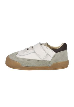 Zapato infantil con parte superior de cuero blanco, acentos de ante gris, cordones elásticos y un tacón marrón. Presenta una suela de goma.