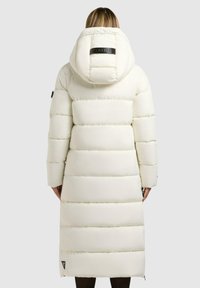 Witte pufferjas met een capuchon, voorzien van een gewatteerd ontwerp en een logo-accent op de achterkant. Lange lengte met zijritsen en elastische manchetten.