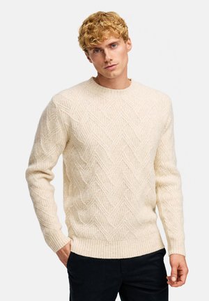 Sweter w kremowym kolorze z teksturowanej dzianiny, z wzorem w zygzak, prążkowanym dekoltem i mankietami, o luźnym kroju.