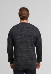 Dunkelgrauer Strickpullover mit geripptem Muster an den Ärmeln und am Rücken, runder Ausschnitt und einem lässigen Schnitt.