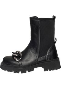 Bottines noires avec une semelle en caoutchouc épaisse, présentant un dessus en cuir lisse et des panneaux latéraux élastiques, soulignées par un détail en chaîne métallique.