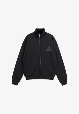 Czarna kurtka zapinana na suwak z wysokim kołnierzem, długimi rękawami i napisem „Varsity Champion” na lewej stronie klatki piersiowej.