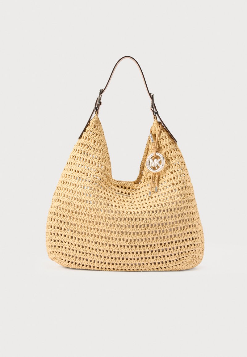 Μπεζ πλεκτή τσάντα ώμου με καφέ δερμάτινο λουράκι και ασημί μενταγιόν με το λογότυπο MK που κρέμεται από τη λαβή.