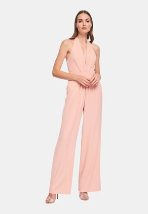 Salopette halter rosa cipria con scollo a V profondo, vita arricciata e pantaloni a gamba larga. Tessuto leggero con texture liscia.