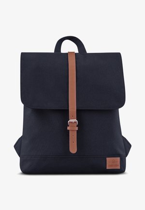 Sac à dos en tissu noir avec une sangle en cuir marron et une fermeture à boucle, poignée supérieure et une petite pièce rectangulaire en cuir dans le coin inférieur droit.