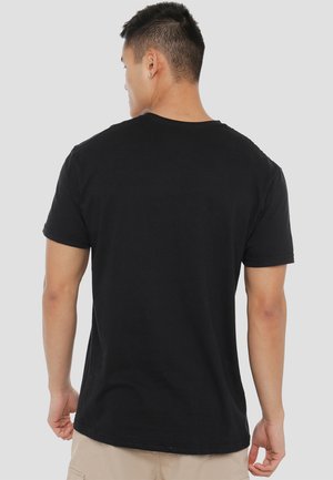 Schwarzes Baumwoll-T-Shirt mit kurzen Ärmeln, rundem Ausschnitt und glatter Textur, von hinten betrachtet. Minimalistisches Design, ohne sichtbare Logos.