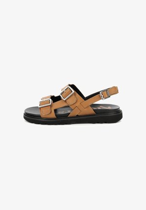 Bruine leren sandalen met twee zilveren gespen, zwarte zool, plat ontwerp, open teen en kruisbanddetails.