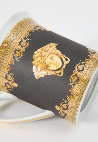 Μαύρο κεραμικό φλιτζάνι με χρυσές λεπτομέρειες, που φέρει σχέδιο της Μέδουσας και περίτεχνο περίγραμμα. Γυαλιστερό φινίρισμα με κυρτή λαβή.