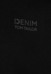 Tessuto nero con una consistenza morbida, decorato da una stampa tonale del logo "DENIM TOM TAILOR" in un carattere moderno. Design semplice e minimalista.