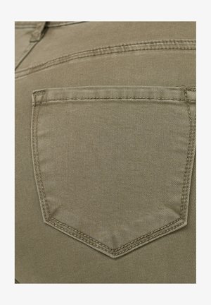 Khakifarbener Denim-Stoff mit einer rautenförmigen Gesäßtasche. Sichtbare Nähte und eine glatte, strukturierte Oberfläche. Einfaches Design, keine zusätzlichen Details.