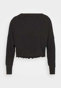 Black cropped top made of ribbed fabric, featuring long sleeves and a scalloped hem. Simple design with a relaxed fit.