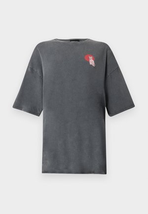 Σκούρο γκρι υπερμεγέθες T-shirt με κοντά μανίκια και μικρό ροζ γραφικό γάτας στο πάνω αριστερό στήθος, μέσα σε κόκκινο οβάλ φόντο.