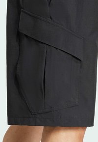 Svarta shorts i en texturerad tygkvalitet med ett vikt paneldesign och en sidficka. Silhuetten är rak och lätt.