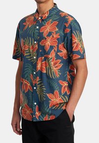 Short-sleeve button-up shirt in dark blue with large red and orange floral patterns and green leaves. Made of lightweight fabric.