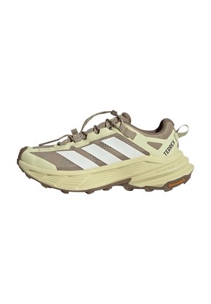 Lyse beige og brune Adidas Terrex trail løbesko med hvide striber, tyk sål og Continental gummiydersål.