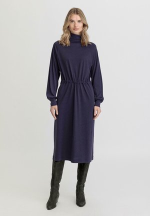 Marineblauwe jurk met hoge hals, lange mouwen en een elastische taille. Gemaakt van zachte stof, knie-lengte met een comfortabele pasvorm.