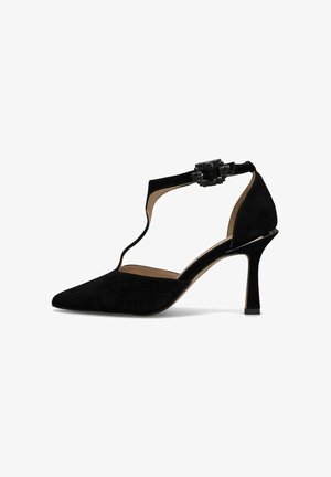 Scarpa nera in suede con tacco alto e punta affusolata, cinturino alla caviglia regolabile con fibbia decorativa e tacco texturizzato.