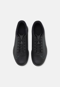 Par de zapatillas deportivas negras con patrón texturizado, cordones y el logo de swoosh, mostradas desde arriba sobre un fondo blanco.