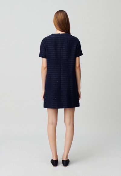 Vestido azul marino de manga corta con rayas texturizadas, corte recto y cierre en la espalda. Detalle de pequeña abertura en la parte posterior; longitud por encima de la rodilla.