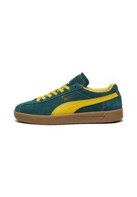 Green suede sneaker with yellow accents, featuring a rounded toe, rubber gum sole, and PUMA branding on the side and tongue.