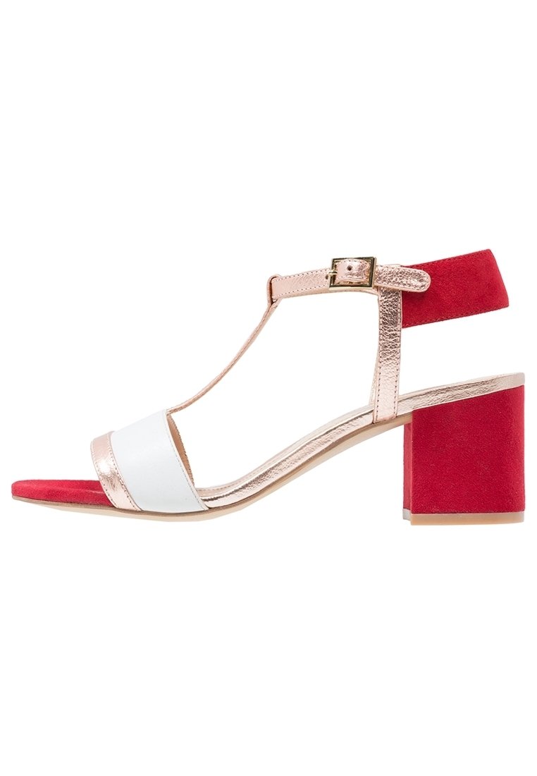 Sandales pour femmes avec une bride métallique en or rose, un bandeau avant blanc et un talon bloc en daim rouge. Design à bride T avec fermeture à boucle à la cheville.
