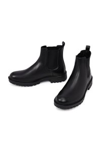 Stivali Chelsea in pelle nera con pannelli elasticizzati ai lati, punta ovale e suola in gomma texture per una presa migliore. Linguetta sul tallone per una facile calzata.