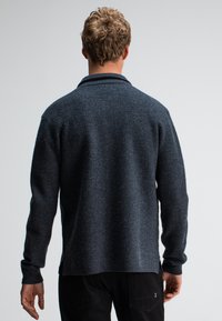 Dunkelgrauer Strickpullover mit klassischem Kragen, langen Ärmeln und seitlichen Schlitzen. Weiche Textur mit lässiger Passform. Rückansicht.