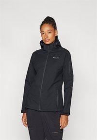 Black waterproof jacket with a zip front, adjustable hood, and side pockets. Features a sleek design and textured fabric for durability.