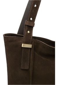 Borsa tote in suede marrone con tracolla in pelle, dotata di ferrature in ottone e dettaglio cucito. L'interno presenta una texture morbida.
