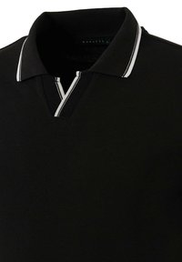 Čierne polo tričko s textúrovanou látkou, pričom má golier a zips. Ozdobené bielymi pruhmi pozdĺž okrajov goliera.