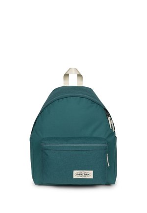 Mochila teal Eastpak con bolsillo delantero con cremallera, asa superior beige y tiradores de cremallera blancos sobre fondo blanco.